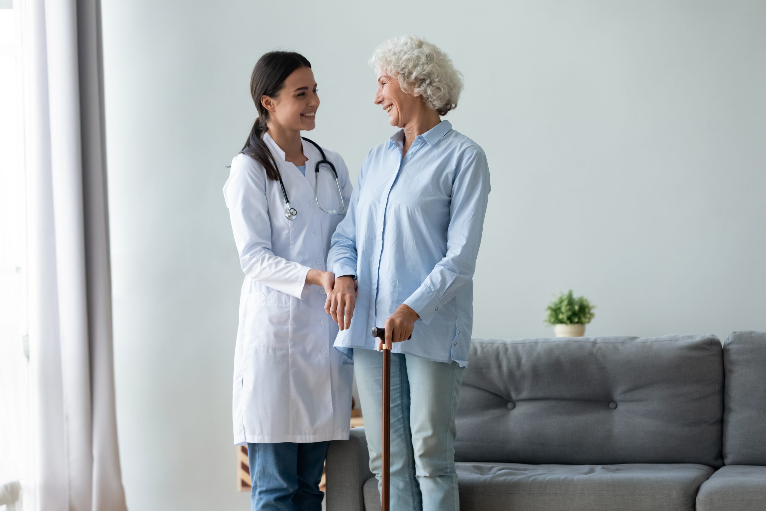 Caring female nurse help senior old lady at home