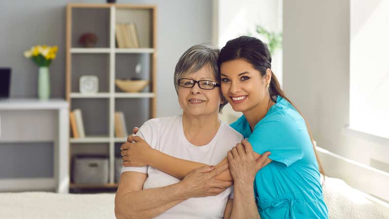 home aid hugging woman in white t-shirt