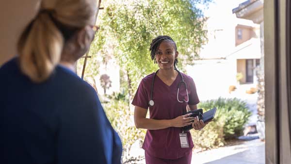 home health care aid arriving at a home - front door visit